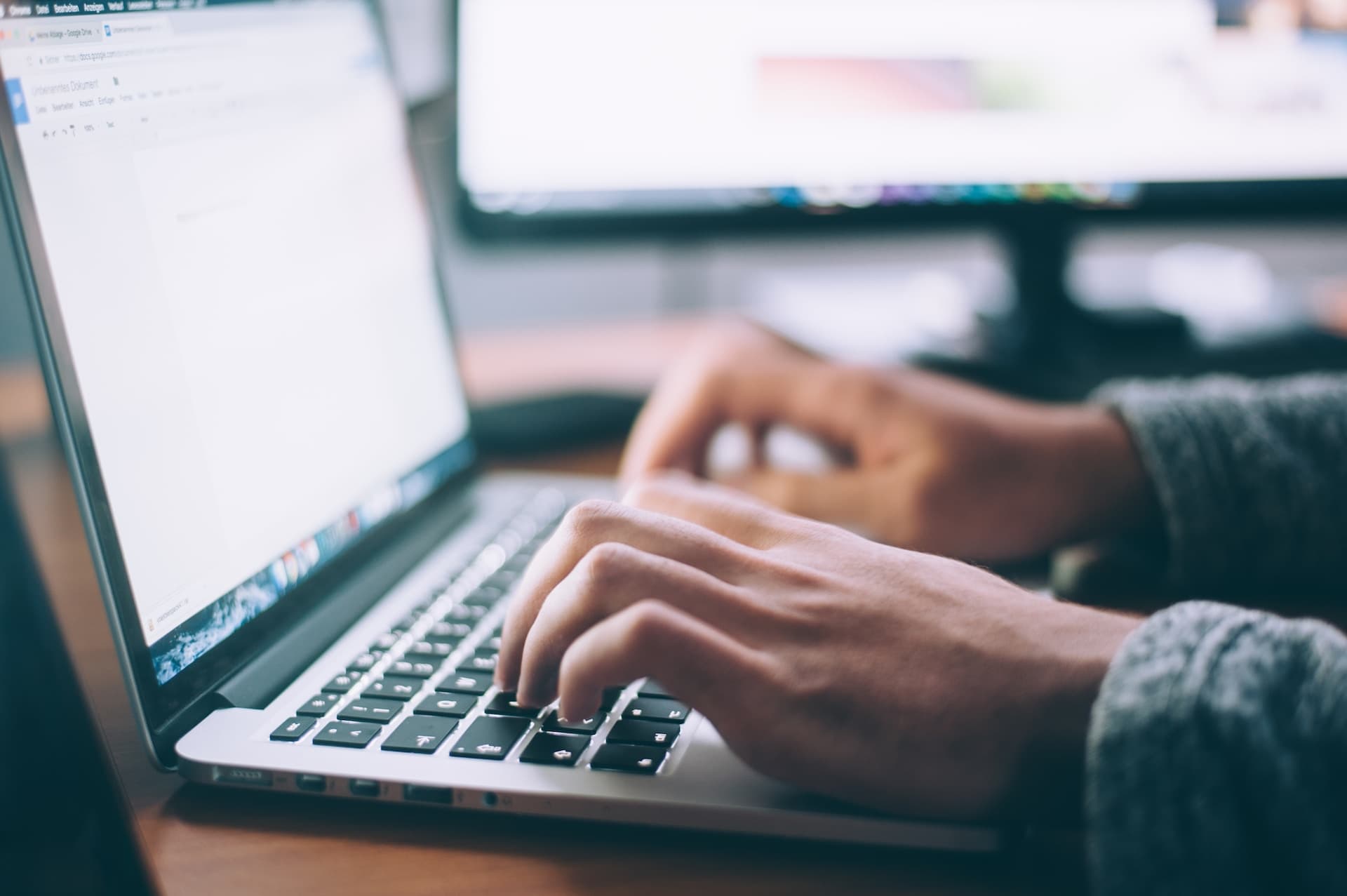 A person typing on MacBook Pro